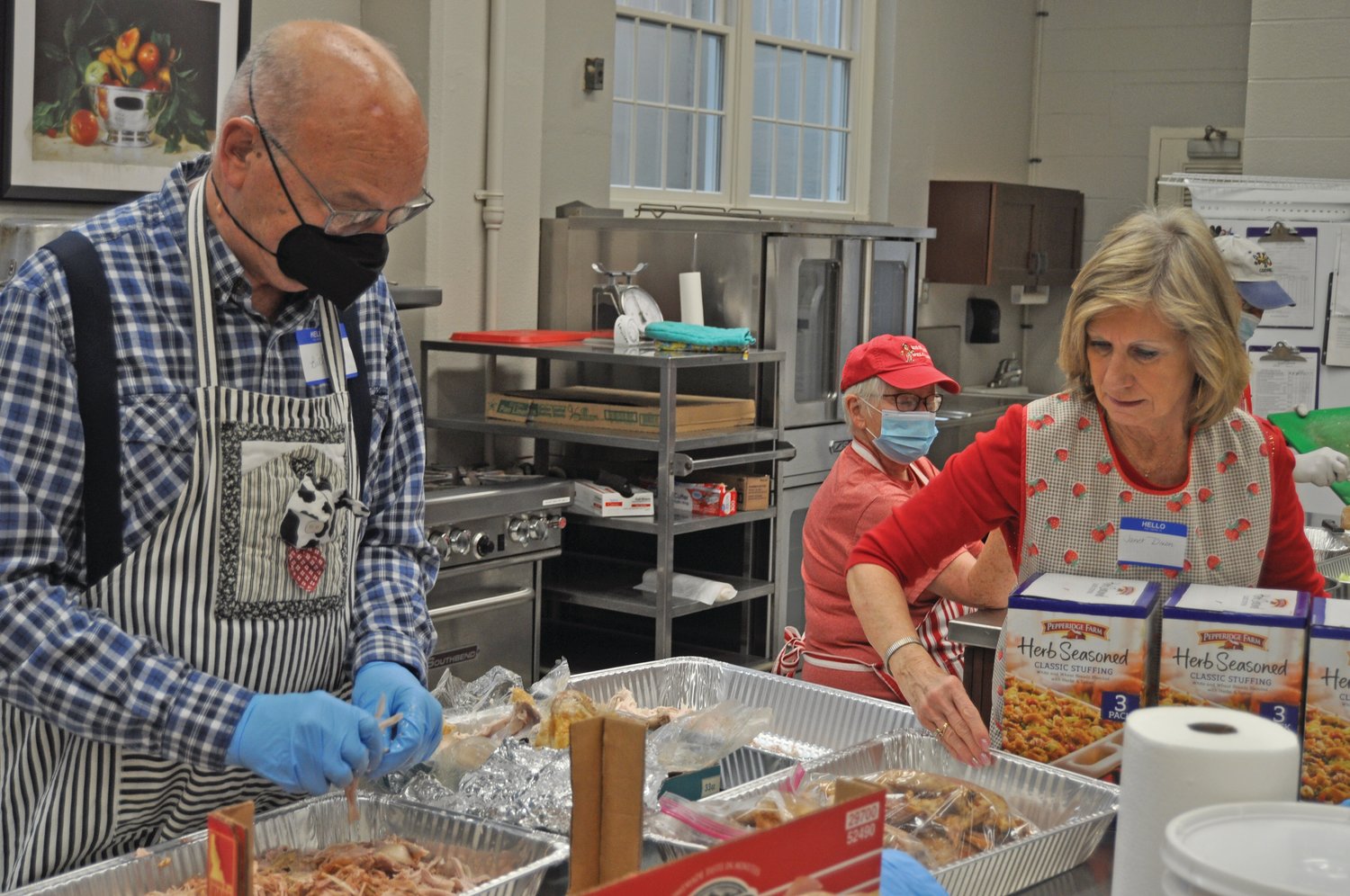 Janet Dixon, right, sets down boxes of stuffing as Bill Doemel prepares a turkey Wednesday during preparations for the Community Thanksgiving Dinner at First United Methodist Church. About 800 people had signed up for a delivered meal and 250-300 people were expected to dine in for the annual tradition.